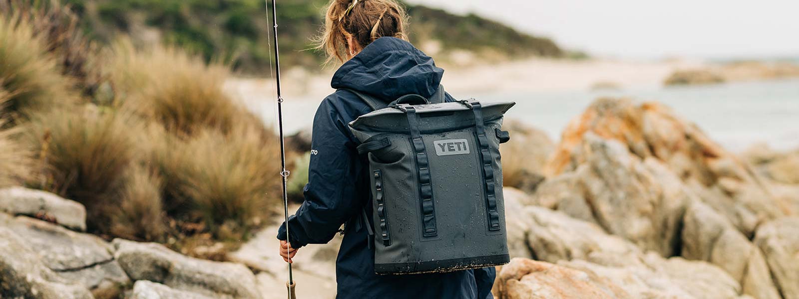 lady with a yeti cooler bag and a fishing rod